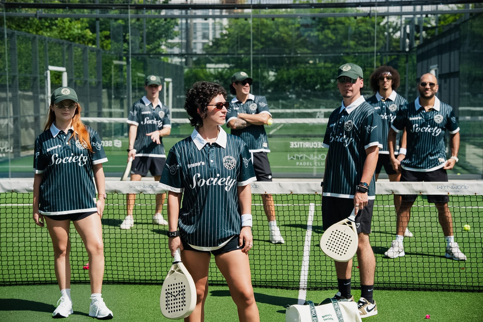 The Bruno's Society team on the padel court in Miami, wearing the Society Jersey and cap